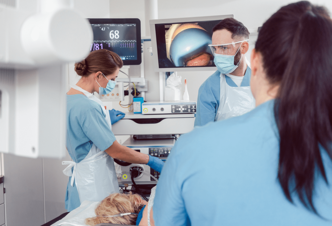  A medical team examining endoscopy images on multiple screens alongside patient data which highlights the importance of seamless integration with other patient management systems.  