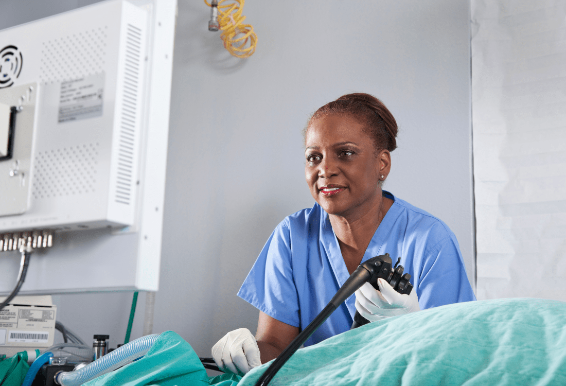 A doctor smiling whilst in the middle of an endoscopy procedure knowing that they’re utilising MEDILOGIK’s cost-effective cloud-based endoscopy management system.